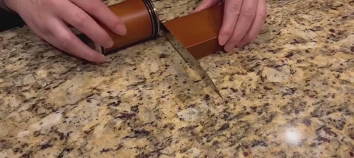 Rolling the sharpener along a chef's knife edge on the magnetic angle block